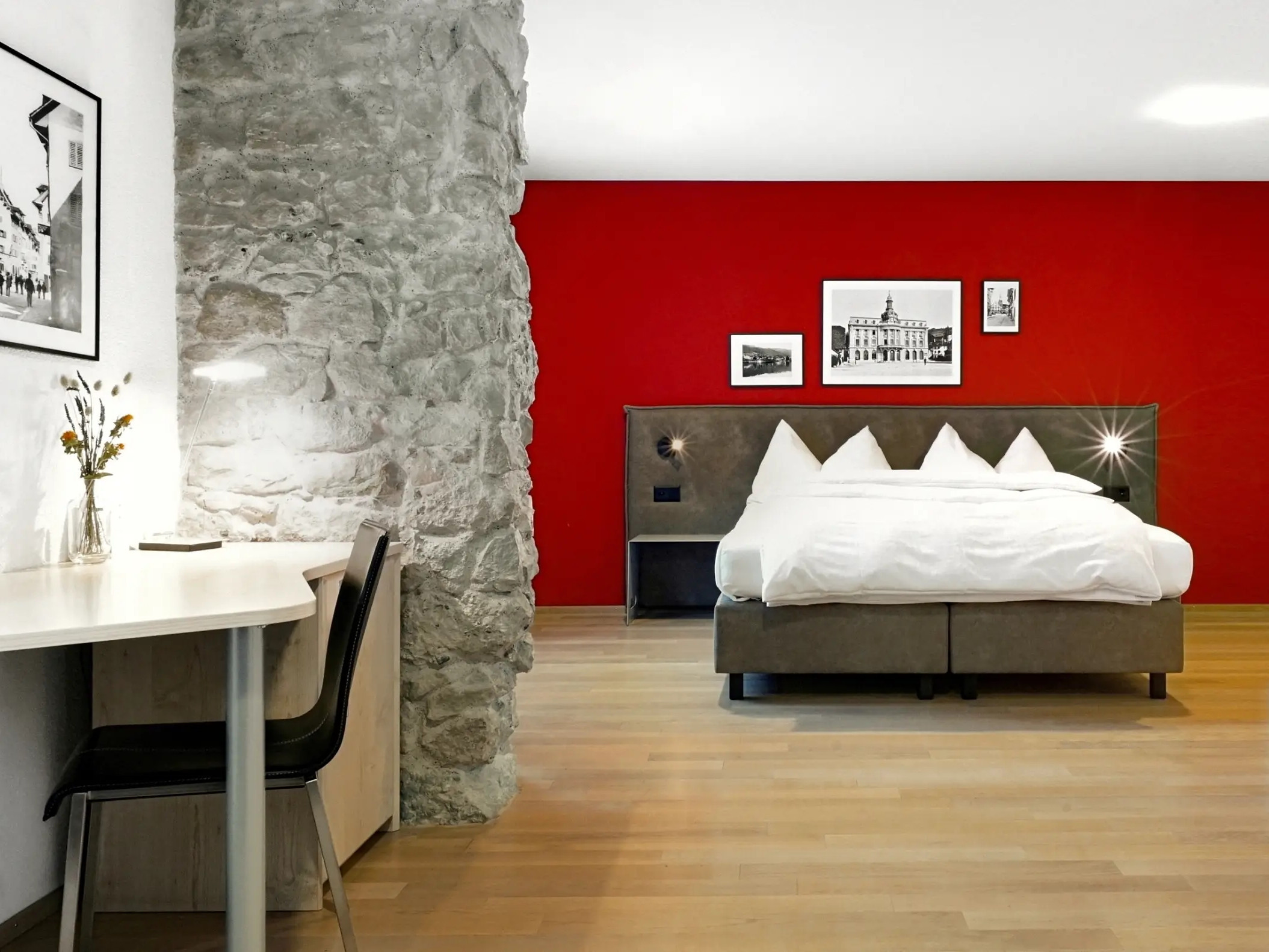 Hotel room in the Zugertor with red wall behind the bed