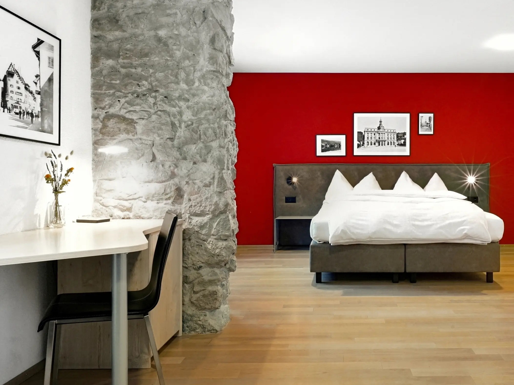 Hotelzimmer im Zugertor mit roter Wand hinter Bett