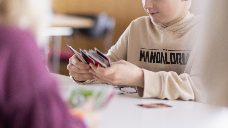 Junge spielt Uno Junge spielt Uno am Tisch