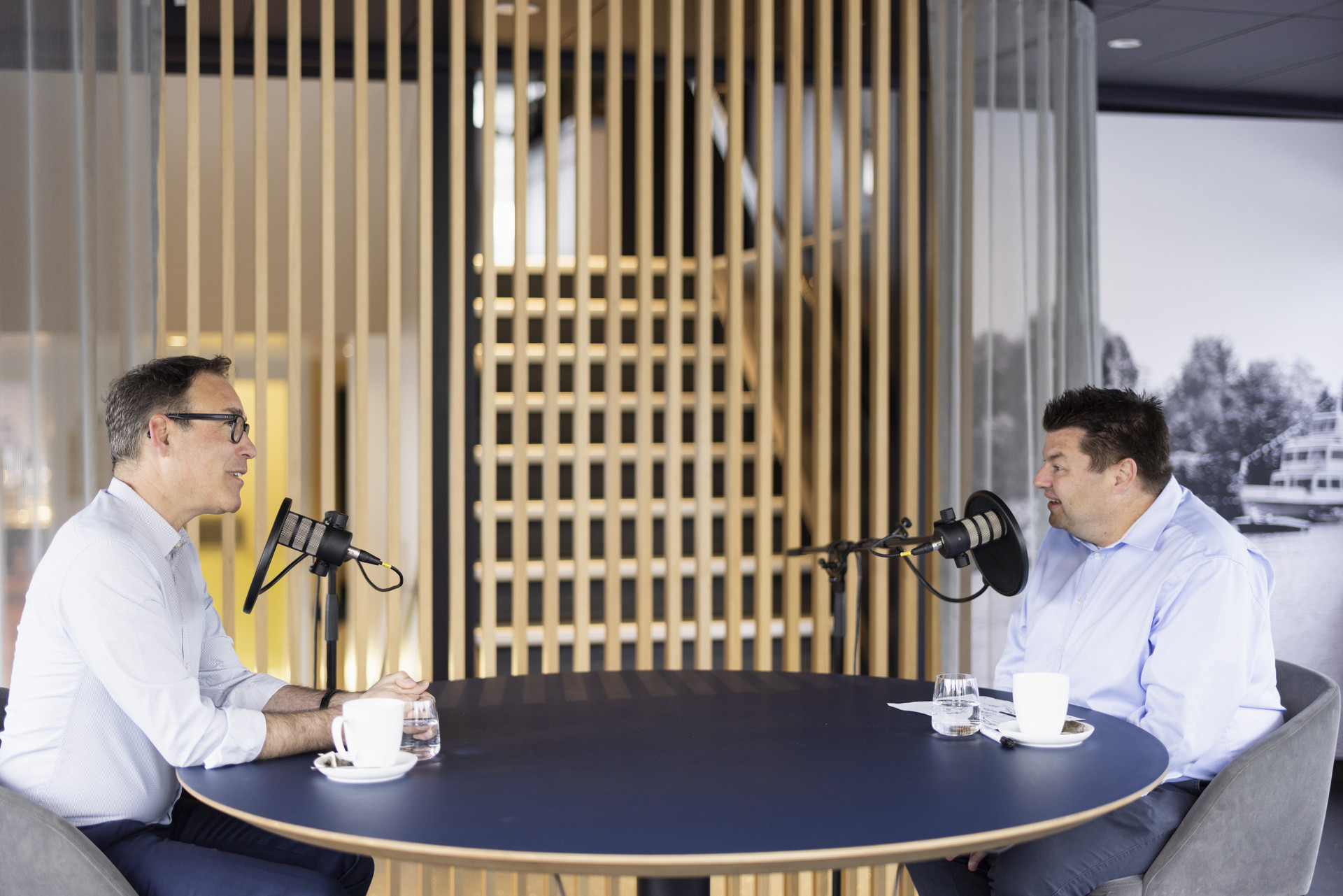 Remo Rey und Philipp Hofmann sitzen hinter dem Mikrophon am Podcasttisch