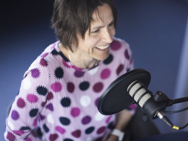 Sara Hübscher als Podcastgast hinter dem Mikrophon