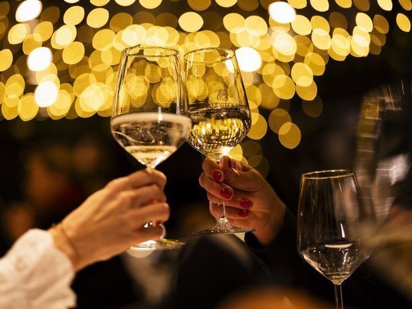 Zwei Hände halten Champagnergläser und stossen an
