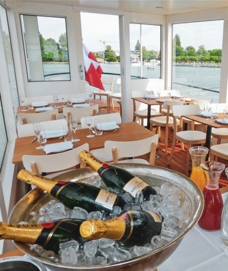 Innenbereich mit vielen Fenstern und mit Tischen und kleinem Buffet