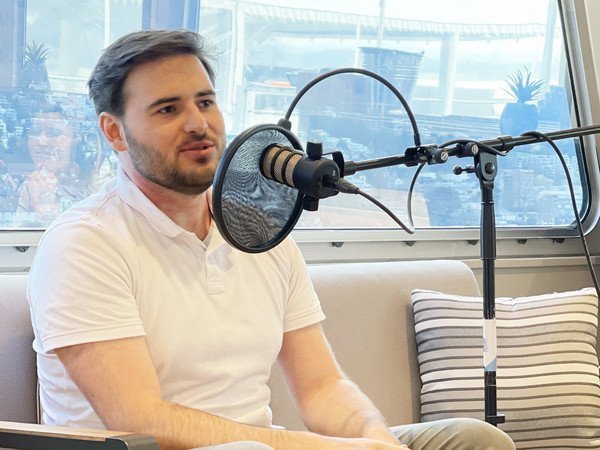 Podcast-Gast David Huwyler, Matrose auf dem Zugersee, hinter dem Mikrophon auf dem Sofa sitzend