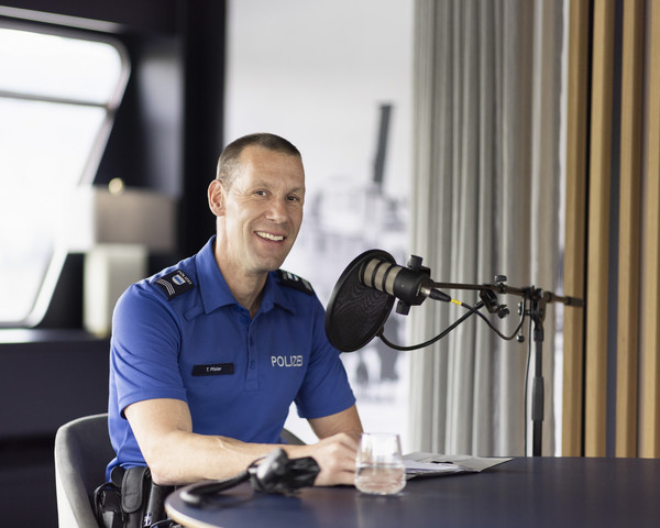 Thomas Pfister von der Seepolizei Zug vor dem Mikrophon am Podcasttisch