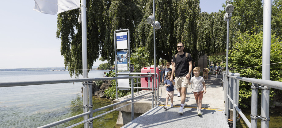Vater mit Kindern am Steg Vater hält seine beiden Kinder an der Hand und geht auf dem Steg
