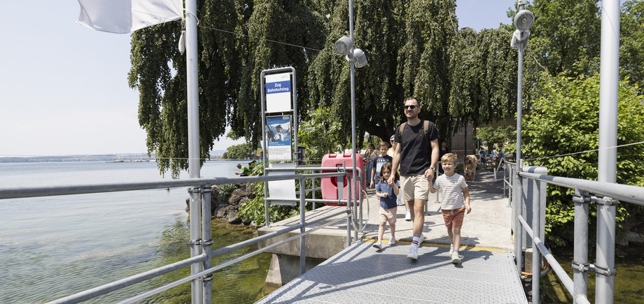 Vater mit Kindern am Steg Vater hält seine beiden Kinder an der Hand und geht auf dem Steg