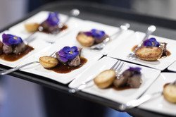 Various beautifully arranged appetisers are offered on the tray.