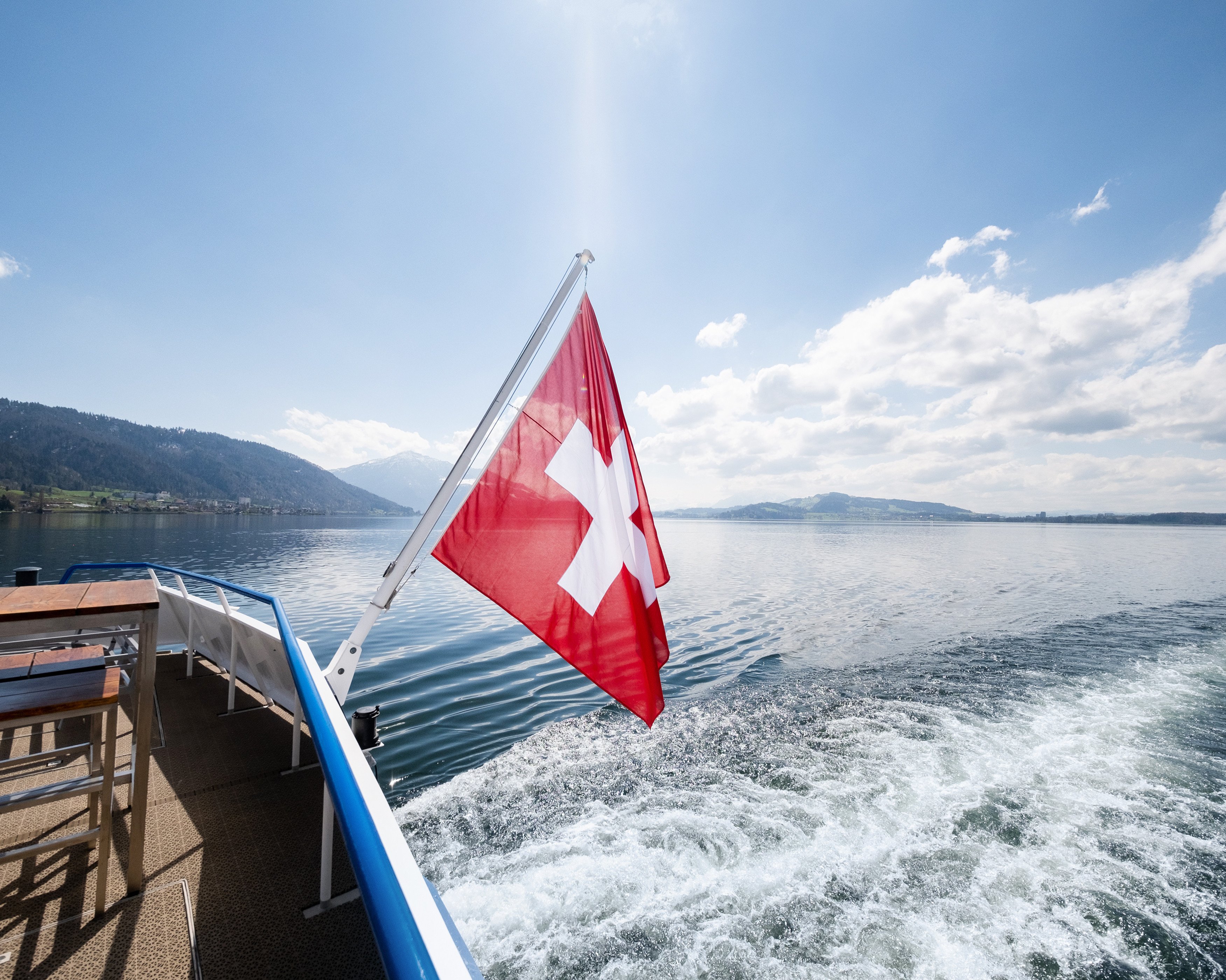 Schweizerfahne Fahne wehend am Heck mit Blick über den See