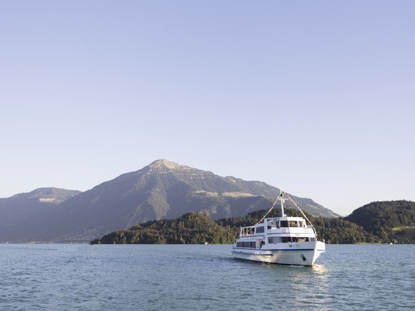 MS Rigi auf dem See mit Berg im Hintergrund