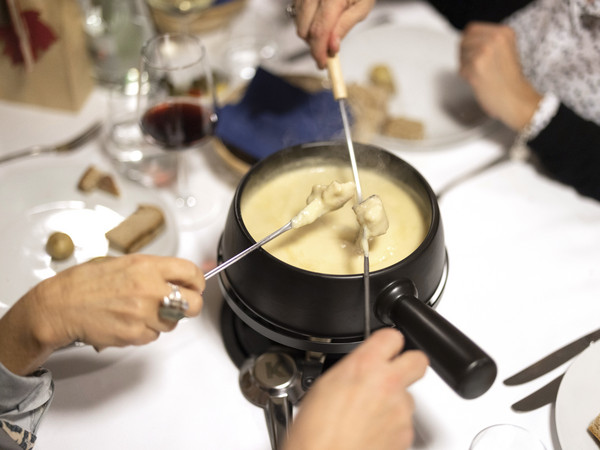 People eating a cheese fondue at the table