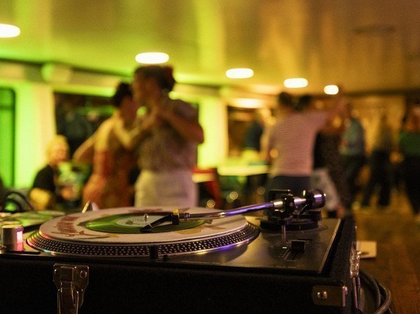 Record player during a musical evening with guests in the background