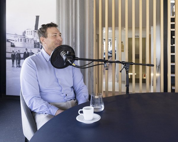Damian Weiss hinter dem Mikrophon am Podcast-Tisch