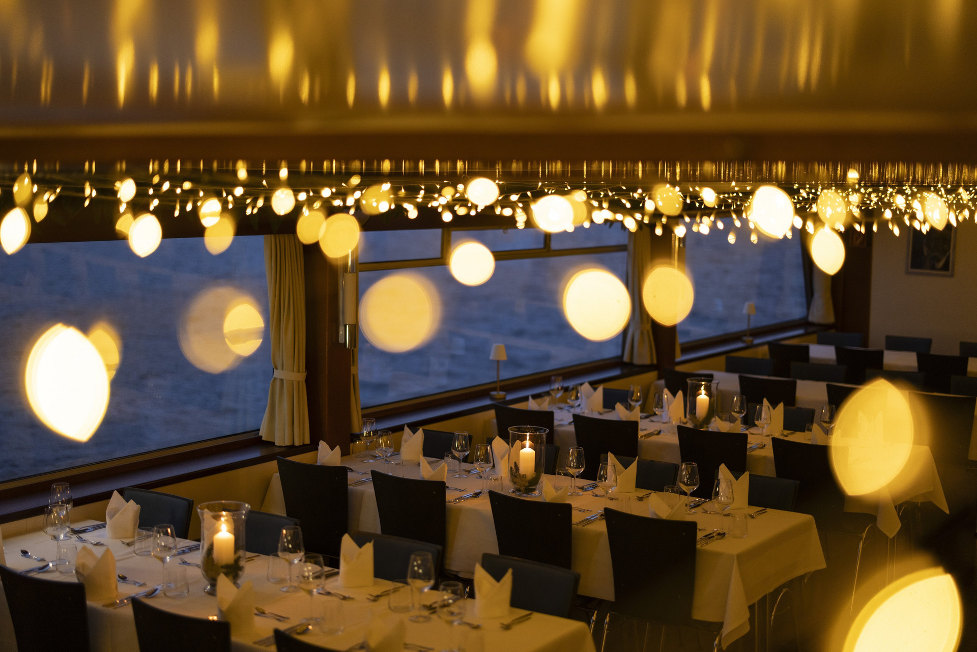 Hauptsalon mit eingedeckten Tischen und Lichterketten an der Decke