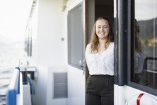 Portrait of an employee standing in the door frame on the moving ship
