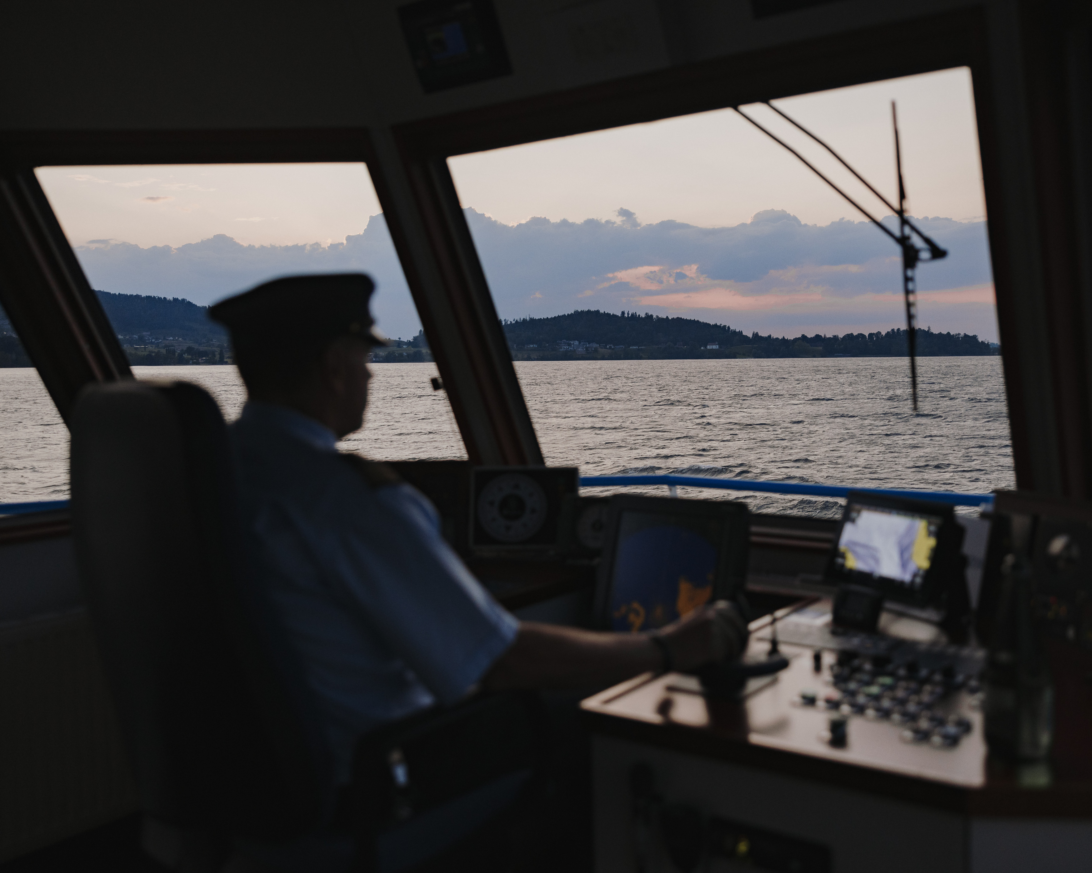 Schiffführer am Steuer auf einer Abendfahrt