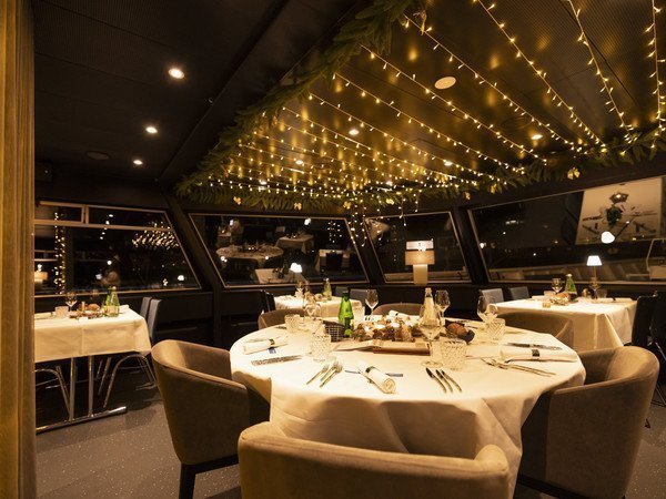 Round table festively set with fairy lights on the ceiling
