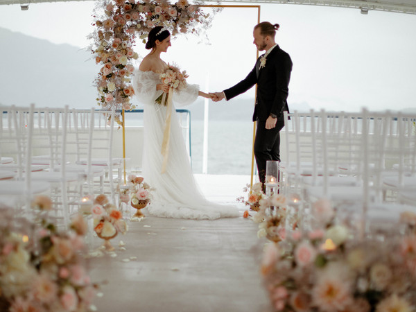 Wedding couple at the wedding arch on the outside deck