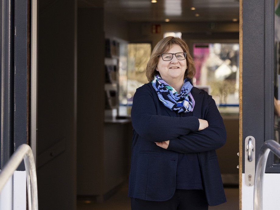 Mitarbeiterin im Türrahmen stehend